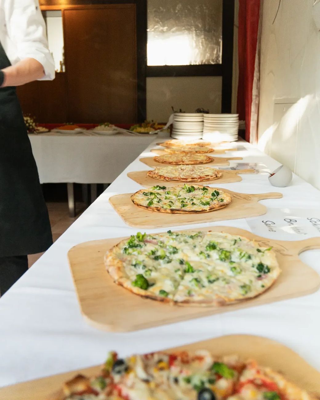 Hochzeitsbuffet: Pizzen auf Holzbrettern in einer langen Reihe